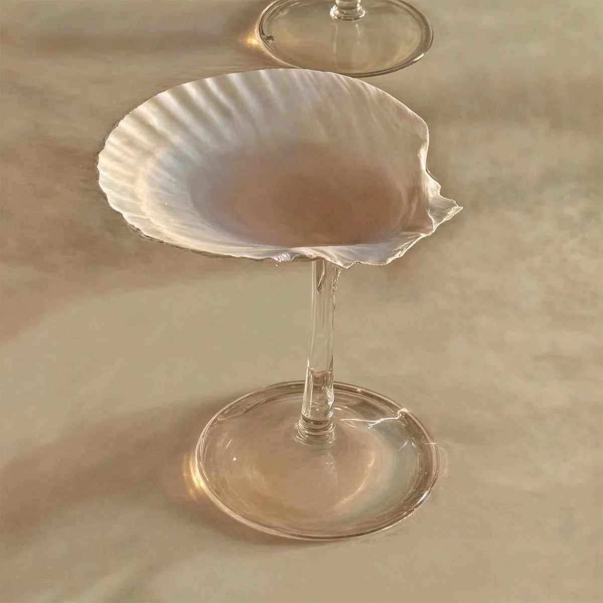 Clear glass with a stem on a beige surface