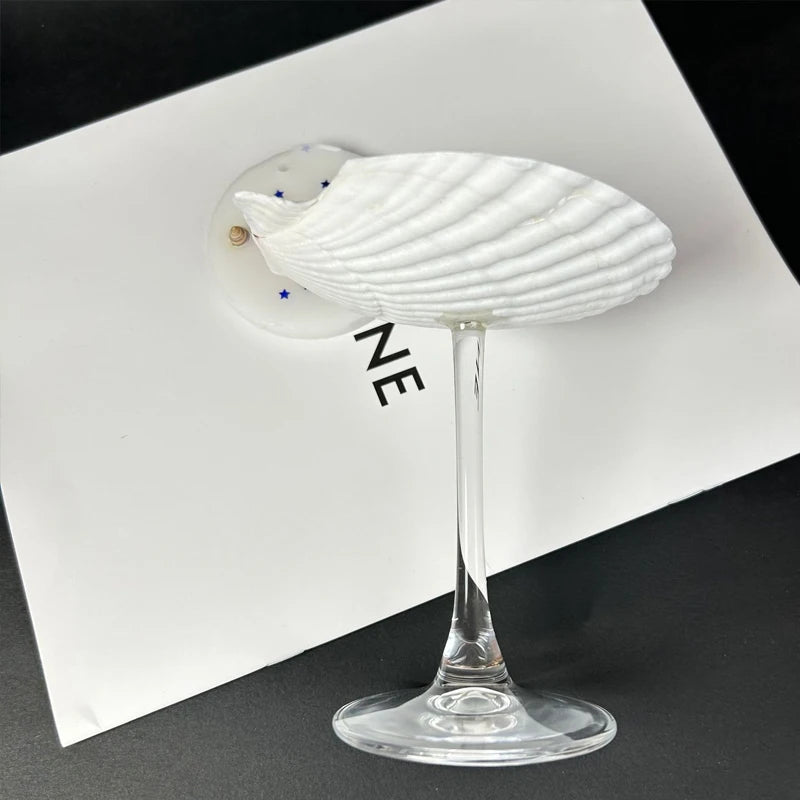 White shell-shaped glass object on a black and white background