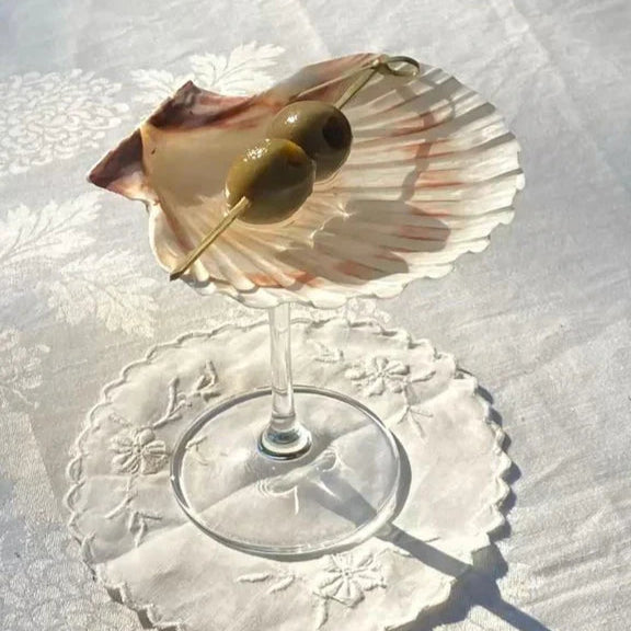Shell on a glass stand with lace doily underneath