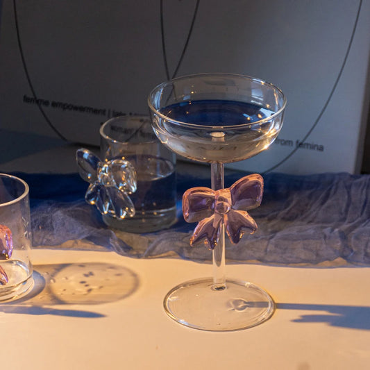 Clear glass with pink bow design on a white surface